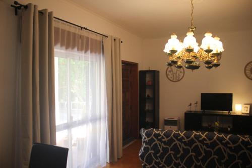 a living room with a chandelier and a window at Casa dos Leme in Baião