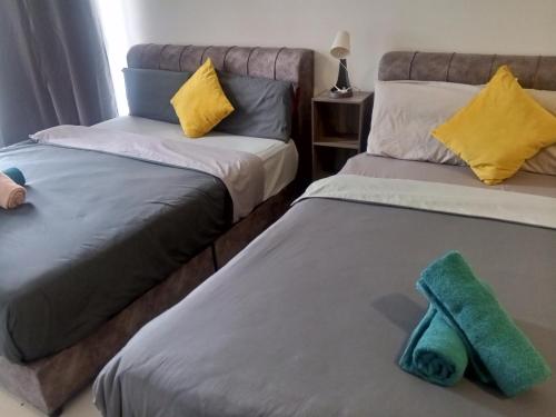 two beds sitting next to each other in a room at Core Soho Suit Kip Sentral Kotawarisan Family Studio Near KLIA & KLIA2 in Sepang
