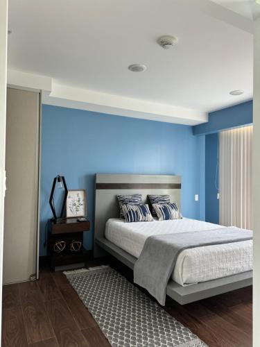 a bedroom with blue walls and a large bed at Lovely Apartment near Costa Rica airport in Heredia