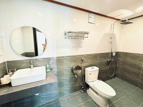 a bathroom with a toilet and a sink and a mirror at Tuan Ngoc Hotel in Ninh Binh