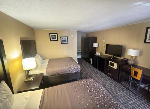 a hotel room with two beds and a flat screen tv at Castlewood Inn in Maggie Valley