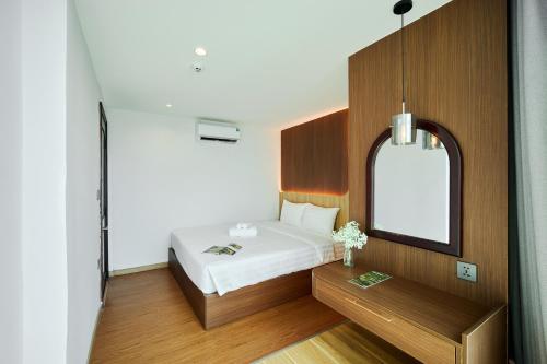 a bedroom with a bed and a mirror at Elite Luxury Hotel in Da Nang