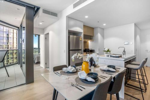 a dining room and kitchen with a table and chairs at Your QW Escape - Pool Gym & Stunning Sky Deck View in Brisbane