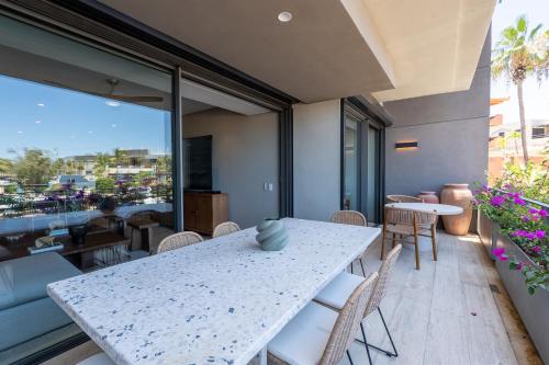 a white table and chairs on a balcony with a view at Punto Nima, Spectacular Pool with Ocean View in San José del Cabo