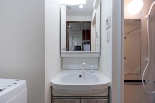 a bathroom with a sink and a mirror at Anri Kitazume in Osaka