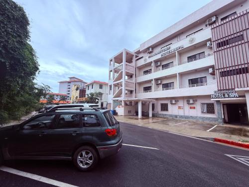 a car parked in a parking lot in front of a building at Hanamitsu Hotel & Spa in Garapan