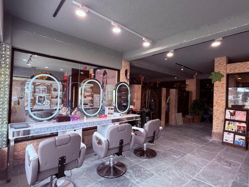 a hair salon with four mirrors andchairs in a room at Hanamitsu Hotel & Spa in Garapan