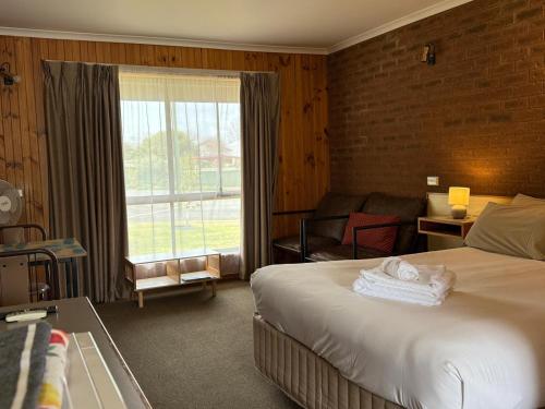 a hotel room with a bed and a large window at Country Roads Motor Inn in Narrandera