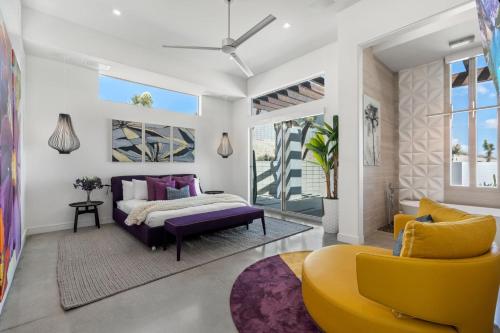 丝兰谷The Overlook by Fieldtrip 5 Bd Modern Luxury with Infinity Pool Views的一间卧室配有紫色的床和黄色椅子