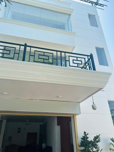 a white building with a balcony with a black railing at Jaffna City Palace Hotel in Jaffna