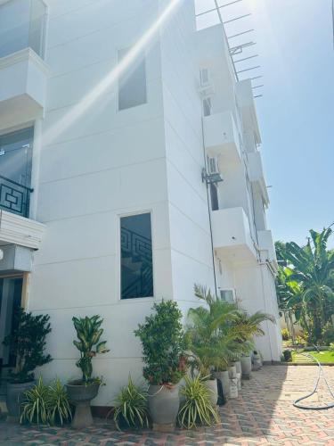 a white building with plants in front of it at Jaffna City Palace Hotel in Jaffna
