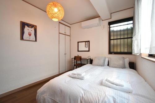 Un dormitorio con una cama blanca con dos toallas encima. en Shinkoiwa 3BR house, en Tokio