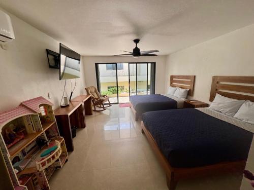 a hotel room with two beds and a balcony at Villa Aurora Beautiful Beachfront Apartment in Cancún
