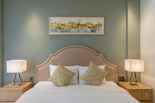 a bedroom with a bed with two lamps on tables at HD Hotel Sunset Town in Phu Quoc