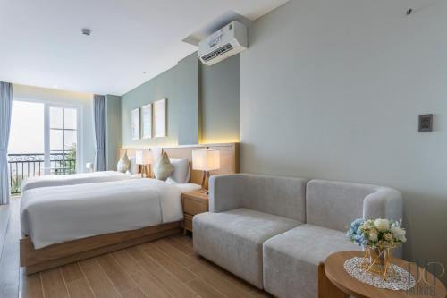 a hotel room with a bed and a couch at HD Hotel Sunset Town in Phu Quoc
