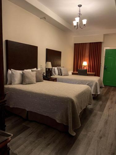 a hotel room with two beds and a window at Hotel Hacienda Santana in Tecate