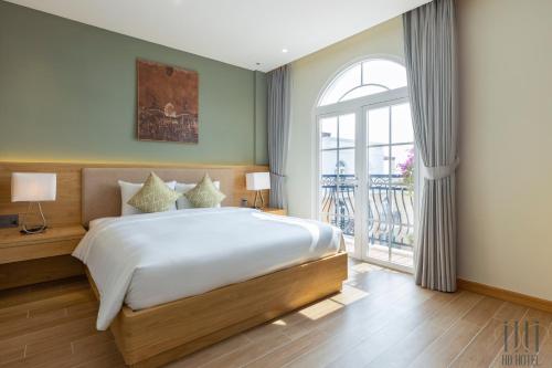 a bedroom with a large bed and a window at HD Hotel Sunset Town in Phu Quoc