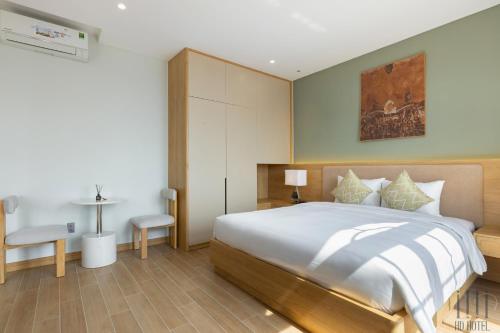 a bedroom with a large bed and a table at HD Hotel Sunset Town in Phu Quoc
