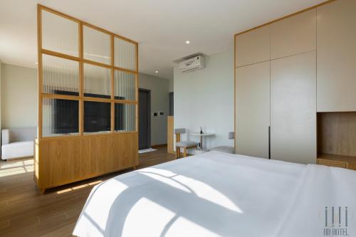 a bedroom with a large white bed and wooden cabinets at HD Hotel Sunset Town in Phu Quoc