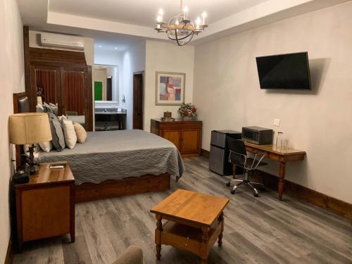 a bedroom with a bed and a desk and a television at Hotel Hacienda Santana in Tecate