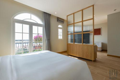 a bedroom with a large bed and a large window at HD Hotel Sunset Town in Phu Quoc