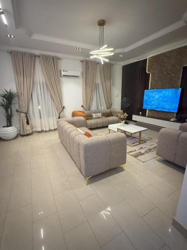 AbeokutaにあるWaldam Castle Apartment Ibaraのリビングルーム(ソファ2台、薄型テレビ付)