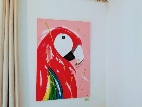 a painting of a red bird on a wall at Don Jiménez Guesthouse in Puerto Jiménez