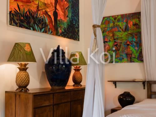 a bedroom with a bed and two vases on a dresser at Villa Koi in Keramas