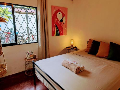 a bedroom with a large bed with a window at Don Jiménez Guesthouse in Puerto Jiménez