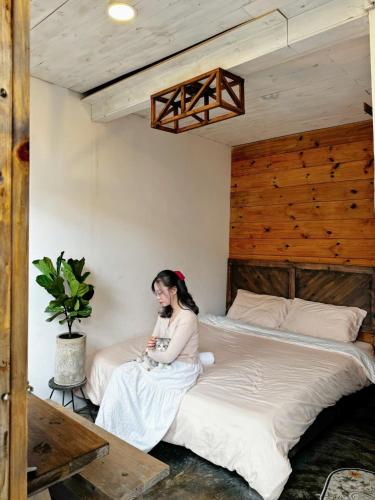a woman sitting on a bed in a bedroom at Nằm Mơ 2 Homestay - chi Nhánh Ngô Quyền in Da Lat