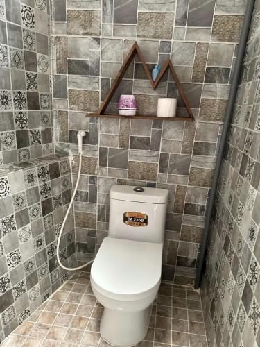 a bathroom with a toilet in a tiled wall at Nằm Mơ 2 Homestay - chi Nhánh Ngô Quyền in Da Lat