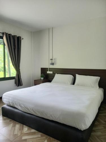 a large white bed in a bedroom with a window at Pimrada in Ban Chieo Ko