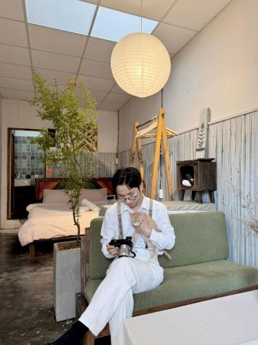 a man sitting on a couch taking a picture with a camera at Nằm Mơ 2 Homestay - chi Nhánh Ngô Quyền in Da Lat
