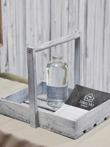 a bottle of water in a wooden box on a table at Nằm Mơ 2 Homestay - chi Nhánh Ngô Quyền in Da Lat