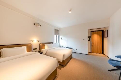 Ένα ή περισσότερα κρεβάτια σε δωμάτιο στο The Moment Hotel