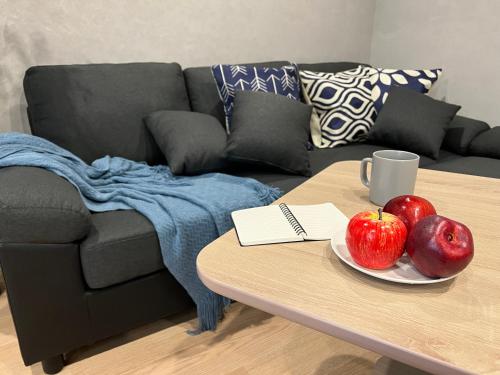 a coffee table with two apples and a mug on it at nestay villa tokyo nippori in Tokyo