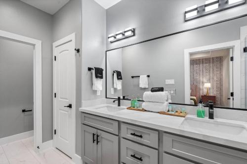 a bathroom with two sinks and a large mirror at The Bayou Bungalow- 5 mins to downtown, 10 to NRG, Sleeps 12, Amazing backyard! in Houston