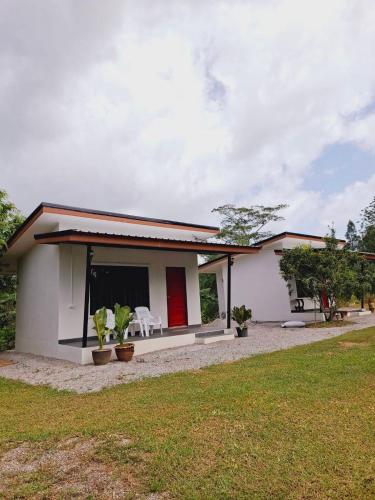 a small white house with a red door at Pimrada in Ban Chieo Ko