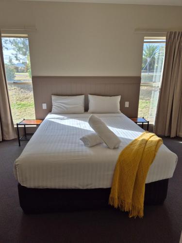 Un dormitorio con una cama grande con dos almohadas. en Pittsworth Motor Inn, en Pittsworth