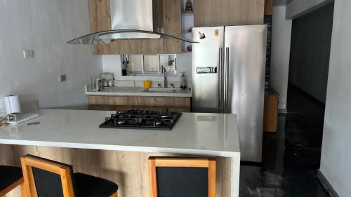 a kitchen with a refrigerator and a counter top at Apartamento Simón Bolívar in Itagüí