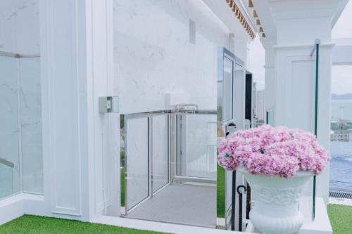 a room with a vase filled with pink flowers at Empire Tower Suite - Luxe 1BR near the Beach in Jomtien Beach