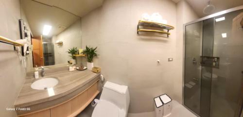 a bathroom with a toilet and a sink and a shower at Eya's Staycation in Baguio