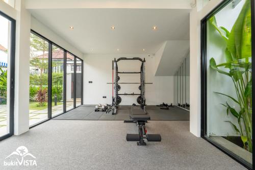 a gym with a treadmill and a bench in a room at Kahuna Villas by Bukit Vista in Sanur