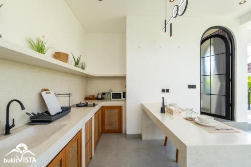 a kitchen with white walls and a large counter top at Kahuna Villas by Bukit Vista in Sanur