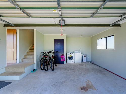 a group of bikes parked in a garage at Beachfront Landing - Pauanui Holiday Home in Pauanui