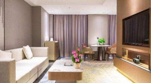 a living room with a couch and a flat screen tv at Chengdu Antai Century Hotel in Chengdu