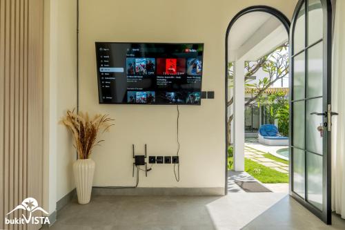 a living room with a tv on the wall at Kahuna Villas by Bukit Vista in Sanur