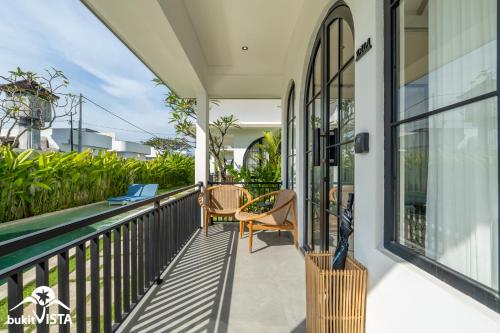 a balcony of a house with chairs and windows at Kahuna Villas by Bukit Vista in Sanur
