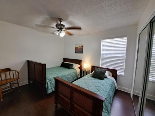 ein Schlafzimmer mit zwei Betten und einem Deckenventilator in der Unterkunft Charming apartment in Kissimmee, Orlando FL in Kissimmee