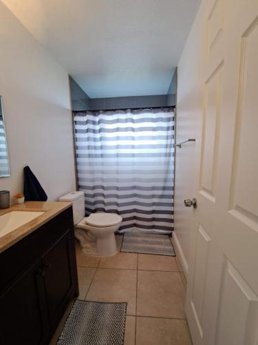 ein Badezimmer mit Toilette und Dusche in der Unterkunft Charming apartment in Kissimmee, Orlando FL in Kissimmee